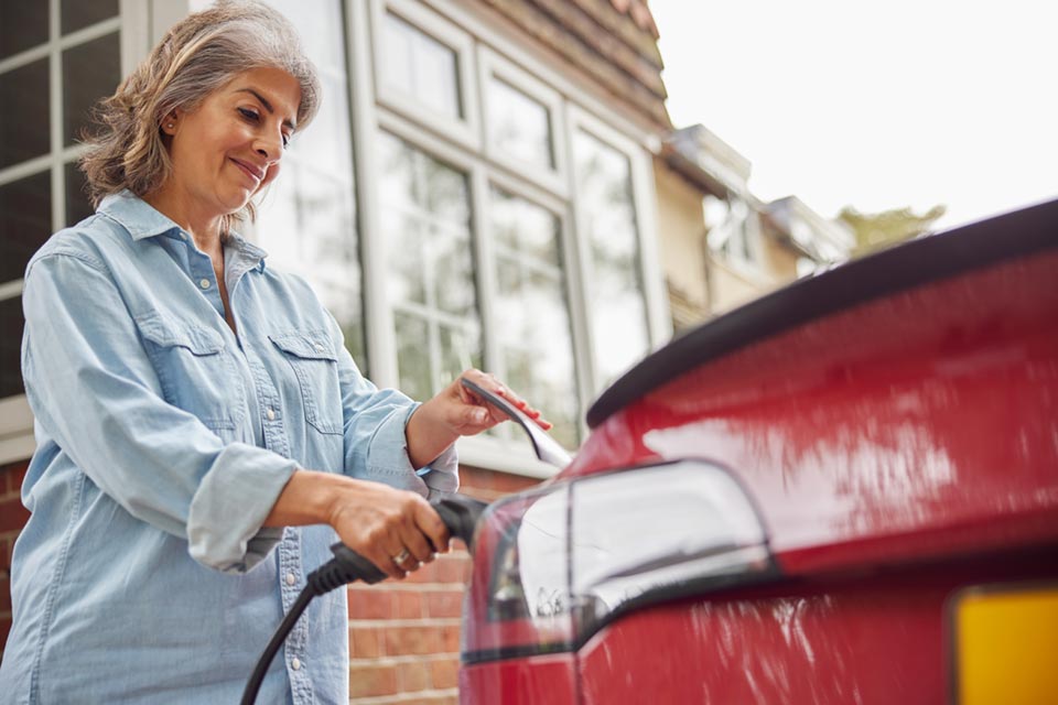 Dame qui recharge sa voiture électrique